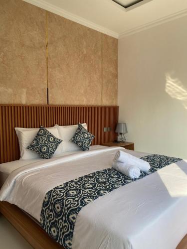 a bedroom with a large bed with blue and white pillows at Villa Bulan by MentariPro Bali in Singaraja