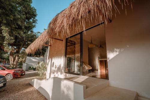 una casa con il tetto di paglia e una finestra di Amarbacalar a Bacalar