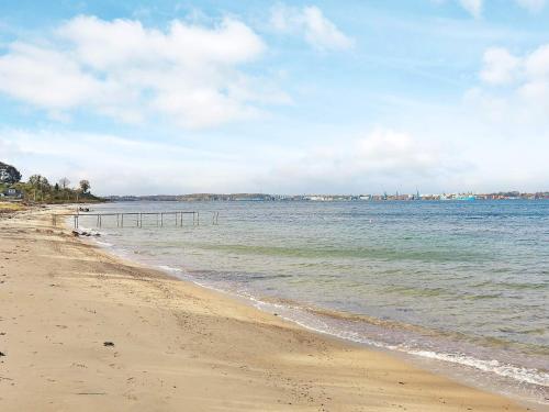a beach with the ocean on a cloudy day at 4 person holiday home in Middelfart-By Traum in Middelfart