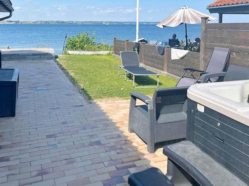 a patio with chairs and a view of the water at 4 person holiday home in Middelfart-By Traum in Middelfart