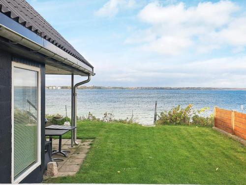 a house with a table and a view of the water at 4 person holiday home in Middelfart-By Traum in Middelfart