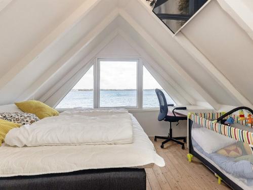 a attic bedroom with a bed and a window at 4 person holiday home in Middelfart-By Traum in Middelfart