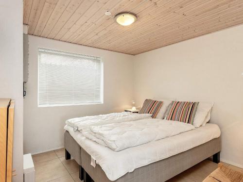 a bedroom with a large white bed with a window at 4 person holiday home in Middelfart-By Traum in Middelfart