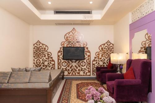 a living room with a couch and a tv at Rasa Boutique Hotel Chiang Rai in Chiang Rai