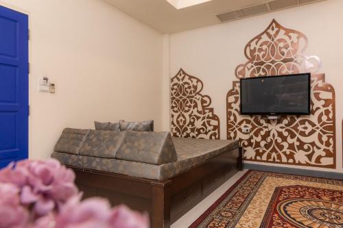 a living room with a couch and a flat screen tv at Rasa Boutique Hotel Chiang Rai in Chiang Rai
