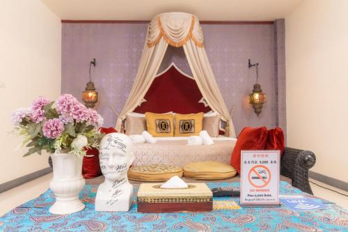 a bedroom with a bed and a table with flowers at Rasa Boutique Hotel Chiang Rai in Chiang Rai