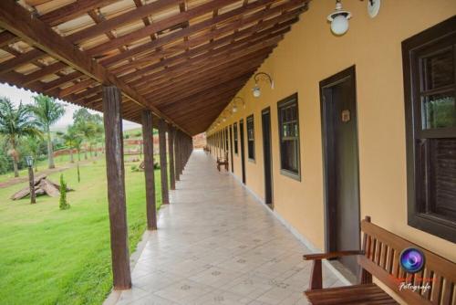 a porch of a building with a wooden pergola at Hotel Fazenda Topada in Baependi