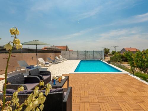 a swimming pool in a yard with chairs at Holiday Home in Lisicic with Pool in Lisičići