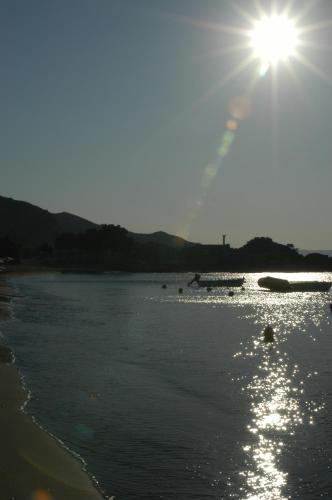 a sun shining over the water on a beach at Maritsa in Kefalos