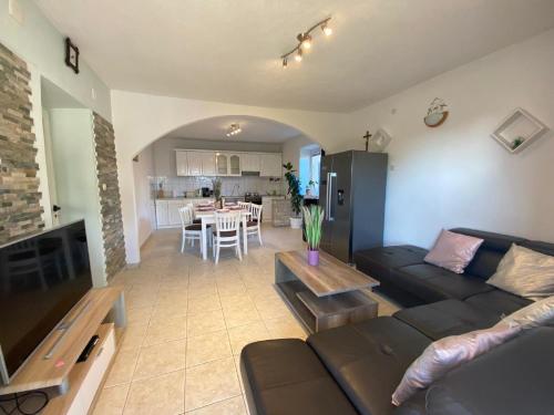 a living room with a black couch and a table at Holiday Home in Lisicic with Pool in Lisičići