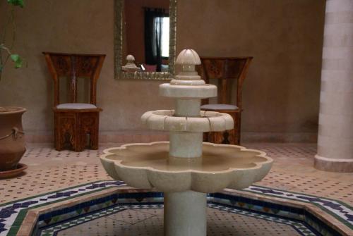 a water fountain in a room with a mirror at Riad Les Jardins de Tafraoute in Foum Mharech
