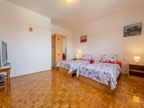 a bedroom with two beds and a wooden floor at Holiday Home in Lisicic with Pool in Lisičići