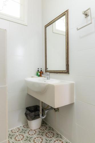 a white bathroom with a sink and a mirror at Rasa Boutique Hotel Chiang Rai in Chiang Rai