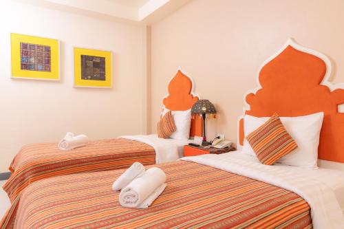 a hotel room with two beds with towels on them at Rasa Boutique Hotel Chiang Rai in Chiang Rai