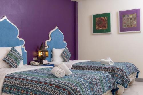 a bedroom with two beds with towels on them at Rasa Boutique Hotel Chiang Rai in Chiang Rai