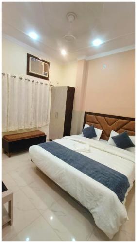 a bedroom with a large white bed with blue pillows at The Aura Hotel Prakash Retreat - Near Kashi-Vishwanath Temple And Ganga Ghat With #Lift #Wi-fi-Restaurant- A Premium Hotel in Varanasi in Varanasi