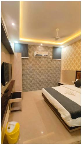 a bedroom with a bed and a television in it at The Aura Hotel Prakash Retreat - Near Kashi-Vishwanath Temple And Ganga Ghat With #Lift #Wi-fi-Restaurant- A Premium Hotel in Varanasi in Varanasi