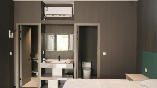 un bagno con un lavandino e un grande specchio di JUNWEI HOTEl a Ban Pho Touane