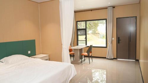una camera da letto con un letto, una scrivania e una finestra di JUNWEI HOTEl a Ban Pho Touane