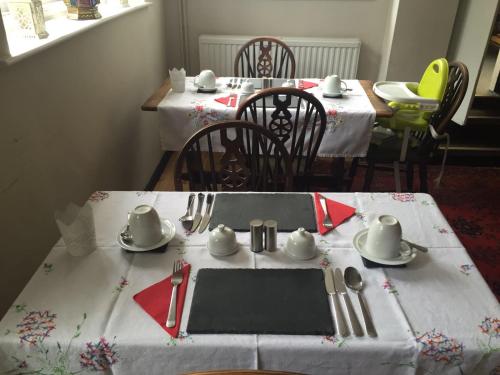 a table with a white table cloth with utensils on it at Red Lion Inn in Sidbury