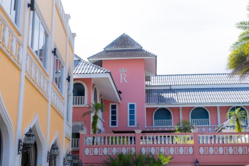 a pink building with a r on it at Rasa Boutique Hotel Chiang Rai in Chiang Rai