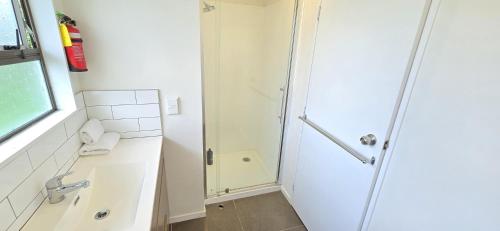a shower with a glass door in a bathroom at Motel 22 in Lower Hutt