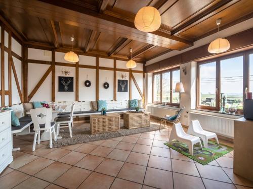 a living room with a table and chairs and windows at Gouvy Getaway holiday home in Gouvy