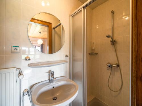a bathroom with a sink and a shower with a mirror at Gouvy Getaway holiday home in Gouvy