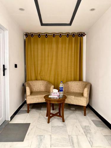 two chairs and a table with a bottle of water at Al Noor Starlet Hotel in Skardu