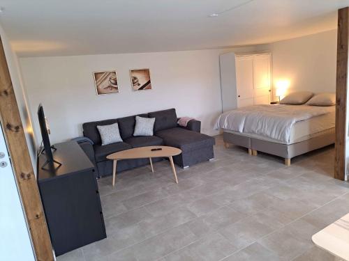 a living room with a couch and a bed at Idyllic Country Apartment Incl All Utilities in Christiansfeld