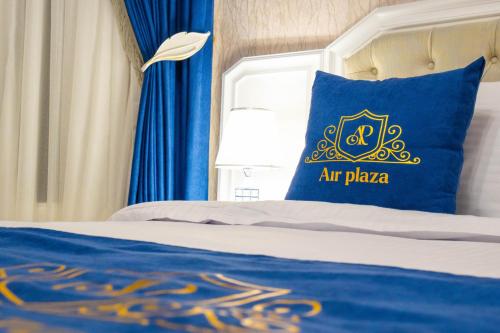 a bed with a blue pillow with the air paza at Air Plaza in Samarkand