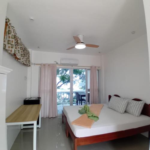 a bedroom with a bed and a desk and a window at Tulang Diot View Resort and Turtle Haven in Camotes Islands