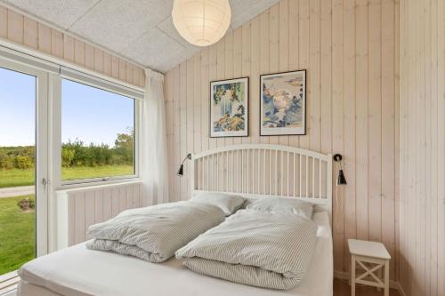 Bogø ByにあるSpacious Holiday Home On Bogøのベッドルーム1室(枕付きのベッド1台、窓付)