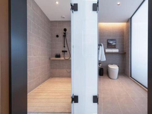 a bathroom with a shower with a toilet in it at Atour Hotel Jinan Tangyan Century Avenue in Jinan