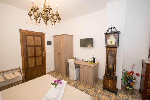 een kamer met een tafel en een grootvaderklok bij B&B Il Muro Vecchio in Giardini Naxos