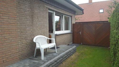 a white chair sitting on a patio next to a window at An der Wilhelmshöhe in Lingen