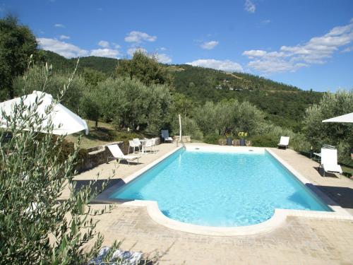 a swimming pool in a resort with a mountain in the background at Villa in Umbertide with Private Pool in Galera