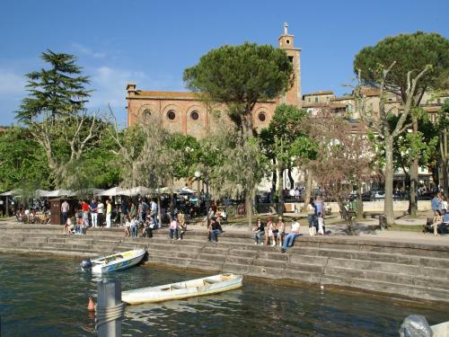 a group of people sitting on steps next to a body of water at Villa in Umbertide with Private Pool in Galera