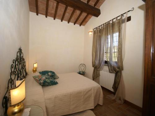 a bedroom with a bed and a window at Villa in Umbertide with Private Pool in Galera