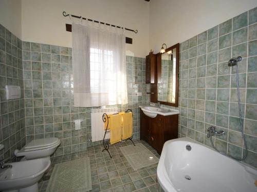 a bathroom with a tub and a sink and a toilet at Villa in Umbertide with Private Pool in Galera