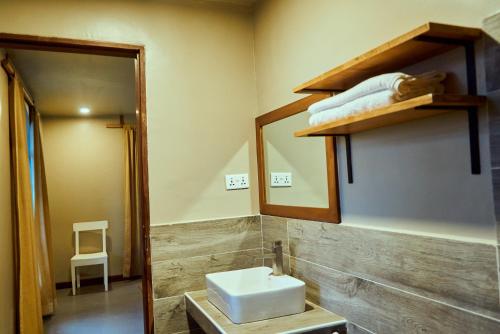 a bathroom with a white sink and a mirror at Mateves Boutique Lodge in Arusha