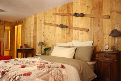 - une chambre avec un grand lit et des murs en bois dans l'établissement Maison Chabod, à Introd