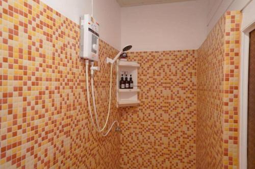 eine Dusche im Bad mit einer gefliesten Wand in der Unterkunft Nornnan Hotel in Nan