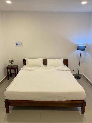 a bed with white sheets and pillows in a room at 22 Homestay-near AEON Mall 3 & Techo International Aiport in Ta Khmau