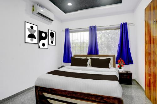 a bedroom with a large bed with blue curtains at Super Townhouse Chhatrapati Shivaji Maharaj Museum Formerly 7 Hills in Aurangabad