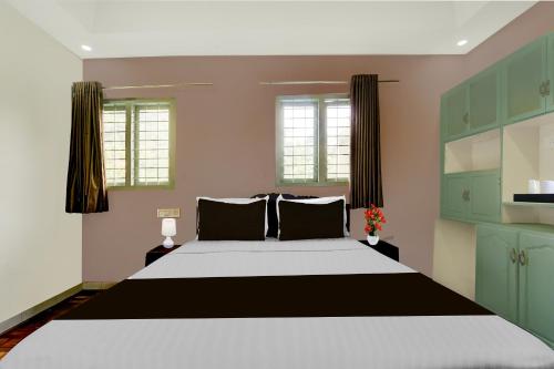 a bedroom with a large bed and green cabinets at Super Collection O Chalakkudy River Annamanada Formerly Svasthya Retreat in Māla