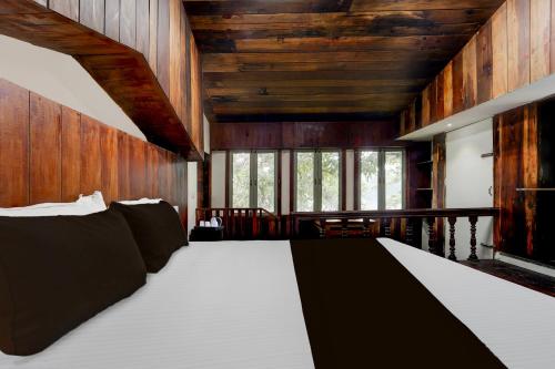 a bedroom with a large bed with wooden walls at Super Collection O Chalakkudy River Annamanada Formerly Svasthya Retreat in Māla