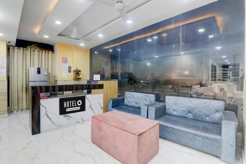 a lobby with two couches and a pink ottoman at Super Hotel O IIM Road Lucknow in Lucknow