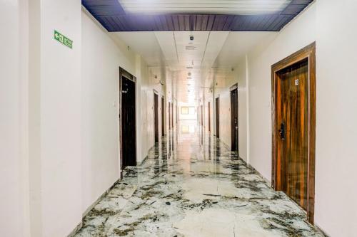 an empty corridor with a marble floor in a building at Super Collection O Ulhasnagar Birla Temple Formerly Hotel Yash Residency in Ulhasnagar