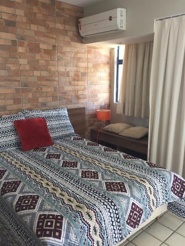 1 dormitorio con 2 camas y pared de ladrillo en Costeira Praia - Belo Flat, en Natal